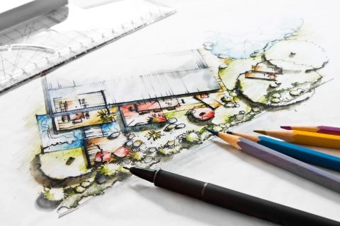 Architektenzeichnung eines modernen Hausgrundrisses mit farbigen Stiften und Lineal.